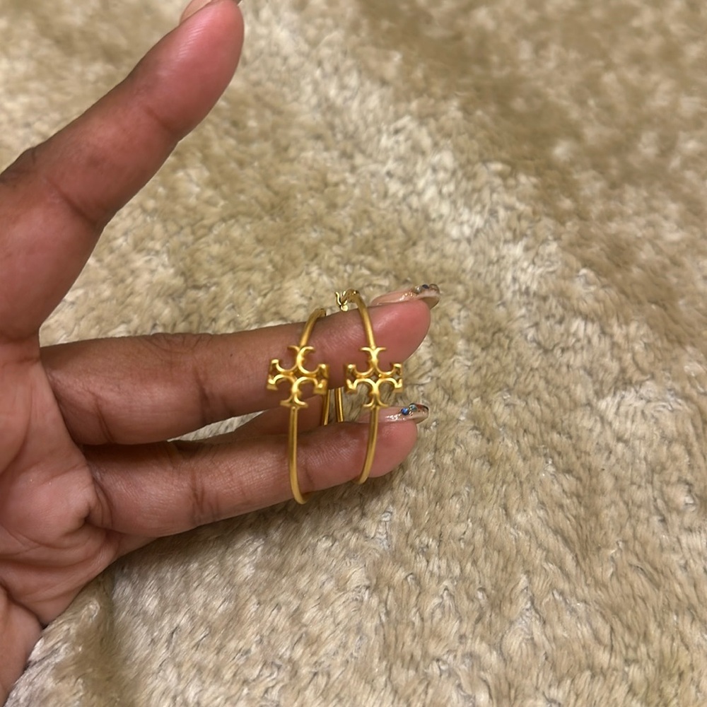 Beautiful Tory Burch gold hoop earrings . Shows signs of loving . Earrings alone